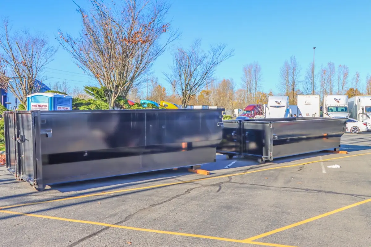 Professional dumpster rental service with roll-off container on residential driveway in Bow